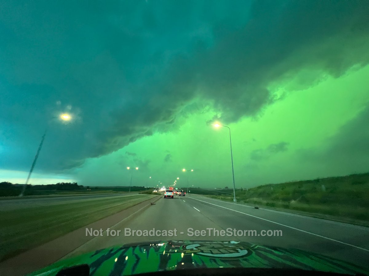 Ciel vert au-dessus d'une autoroute à l'approche d'un orage violent.